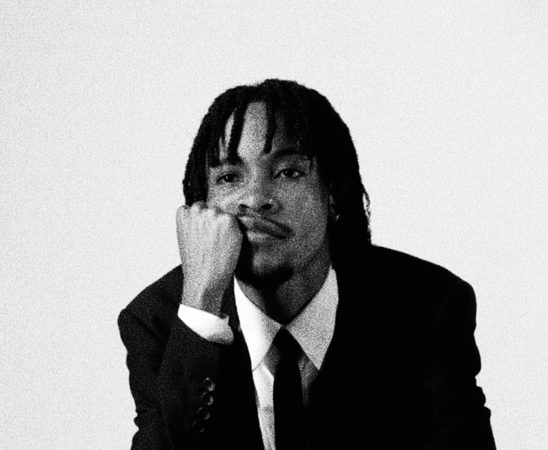 Portrait of HIGHBREED resting his chin on his hand